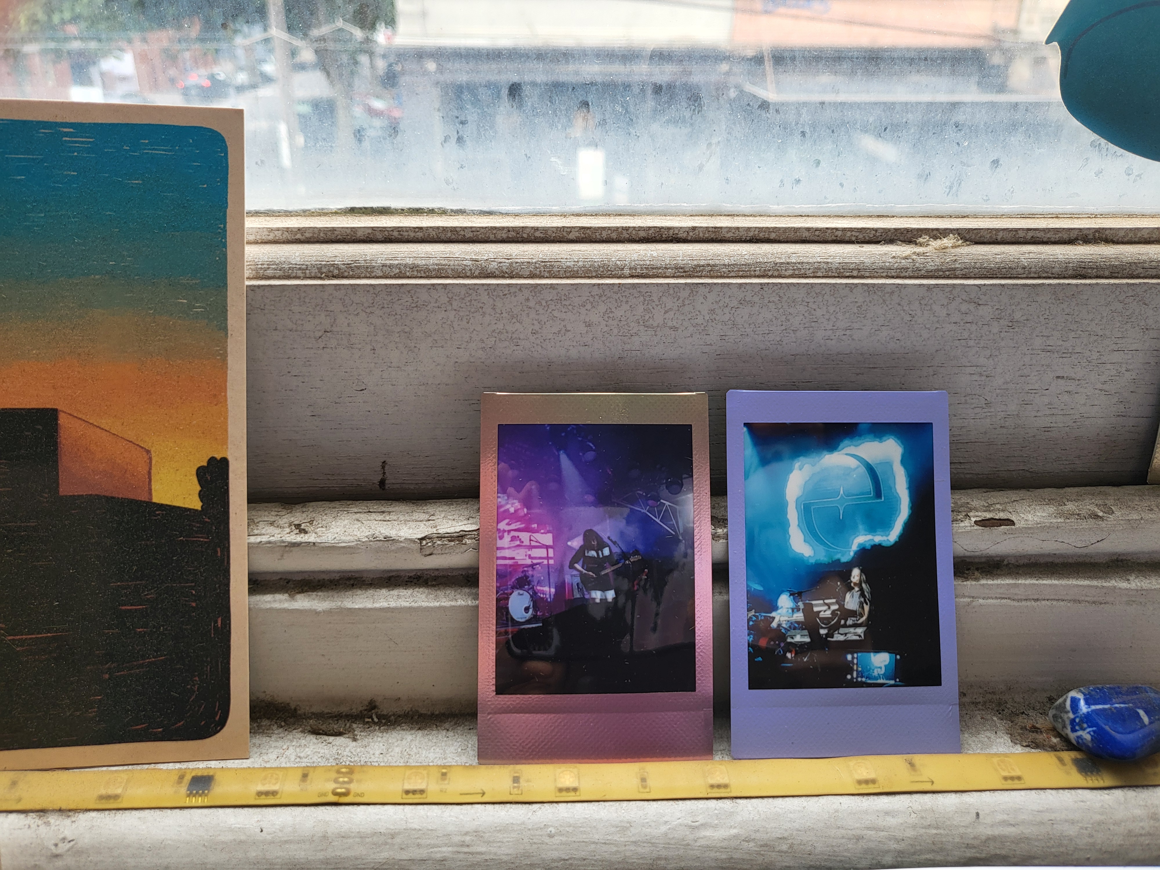 instax poloroid photos of Romy Vega playing guitar and Amy Lee playing keyboards, sitting on a window sill